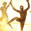 Silhouettes of a man and woman joyfully splashing in water, celebrating summer family fun activities.