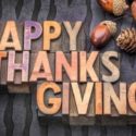 Wooden letters spelling 'HAPPY THANKSGIVING' with acorns and pine cones, creating a festive home decor scene.