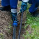 Worker in gloves managing cables outdoors, showcasing utility installation for Laney's Inc. home services.