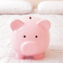 Pink piggy bank on white bedding, representing savings, alongside HVAC maintenance tips on Laney's Inc. website.