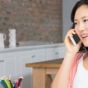 Woman on a phone call at a desk with colorful pencils, representing Laney's Inc. home service tips.