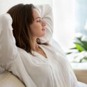 Woman relaxing indoors with a serene expression, promoting good indoor air quality and comfort in home environments.