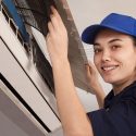 Woman technician servicing an air conditioning unit, representing women in the HVAC industry, emphasizing diversity in plumbing and HVAC careers.