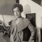First woman to graduate with an engineering degree from the University of Kentucky in 1916, holding a device related to air conditioning, symbolizing contributions to HVAC industry.