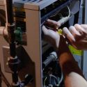Hands working on electrical equipment, showcasing maintenance for home service provider Laney's Inc.