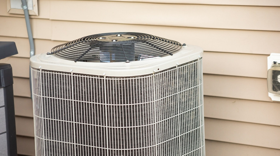 Air conditioning unit outside a home, highlighting the importance of AC maintenance and replacement in maintaining indoor comfort and efficiency.